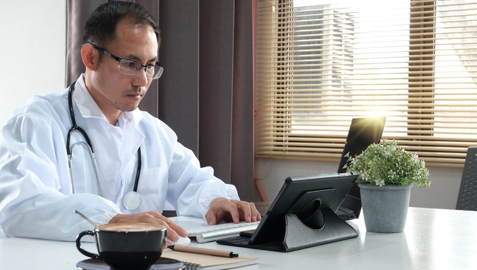 doctor reading about transverse myelitis in his tablet