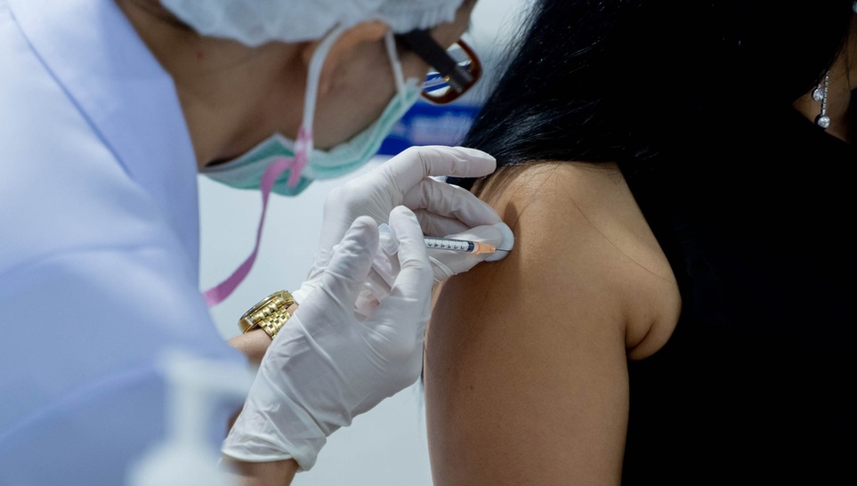 woman being vaccinated by a doctor with flu vaccine