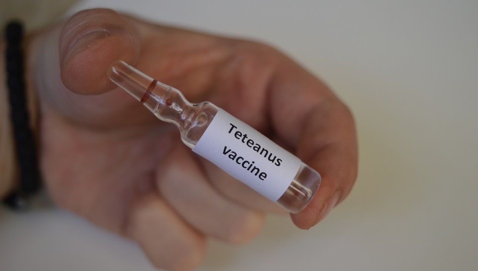 a bottle of tetanus vaccine in one hand