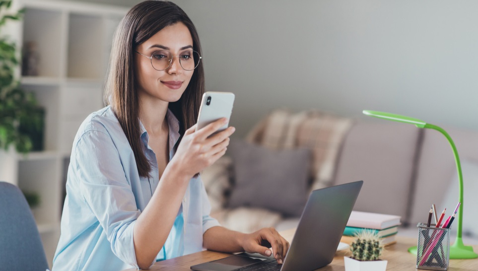 woman reading an article about how often should you get a tetanus shot in her phone while sitting on her desk