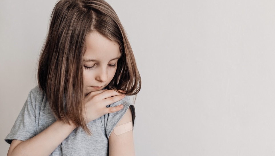 child checking her injured shoulder because of a vaccine