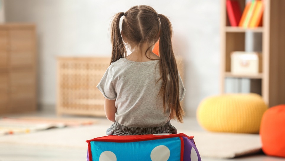 lonely child sitting in the middle of a room