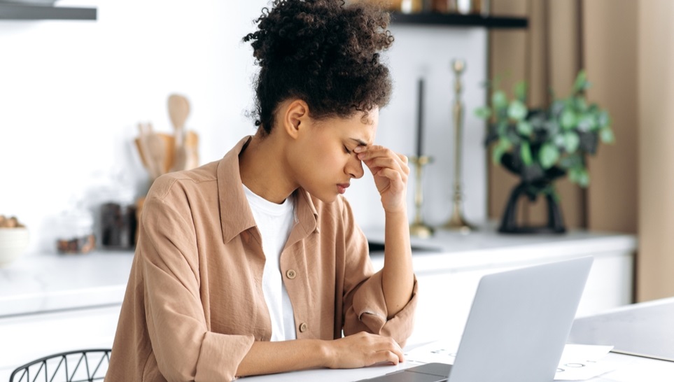 woman feeling fatigue while working on her desk