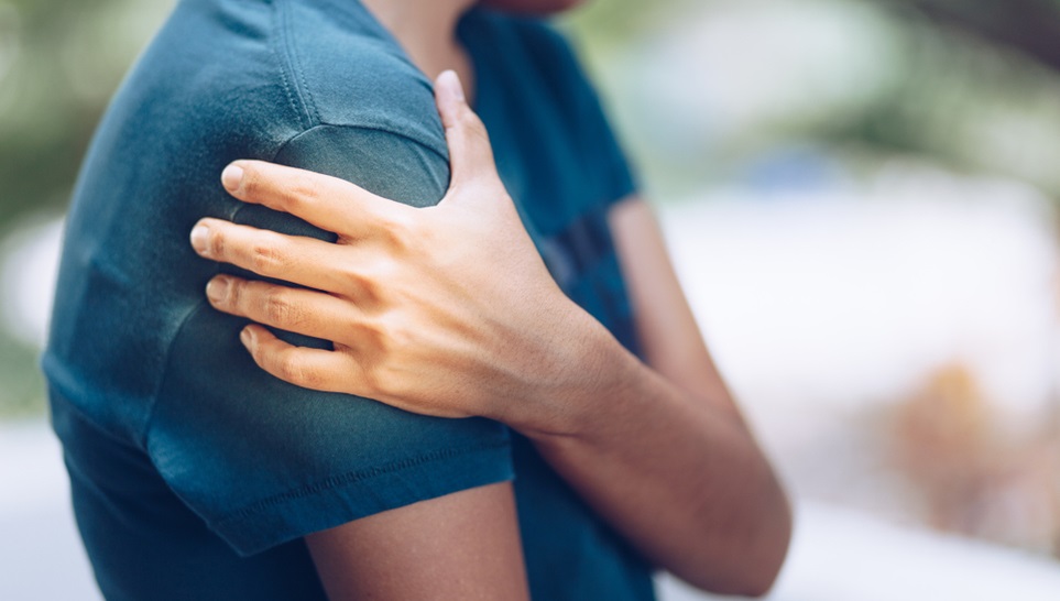 man feeling his shoulder after vaccination