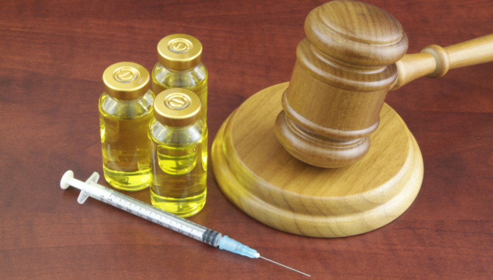 syringe vaccine and judge gavel on wodden background
