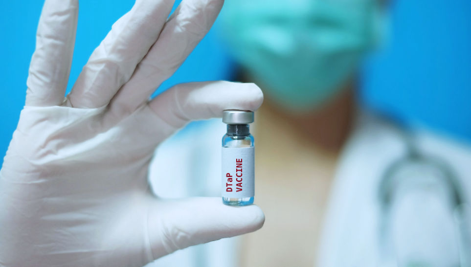 female nurse holding a dtap vaccine