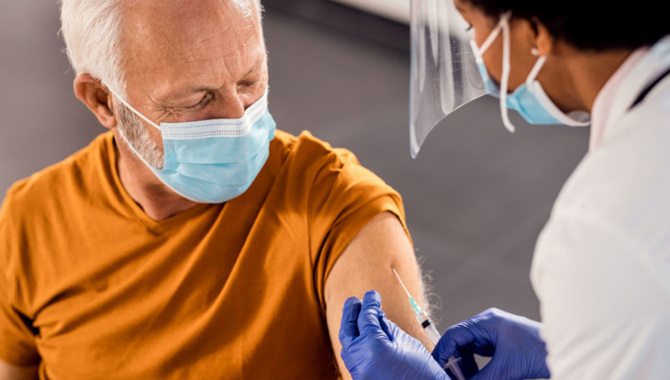 male senior patient getting vaccinated at medical clinic