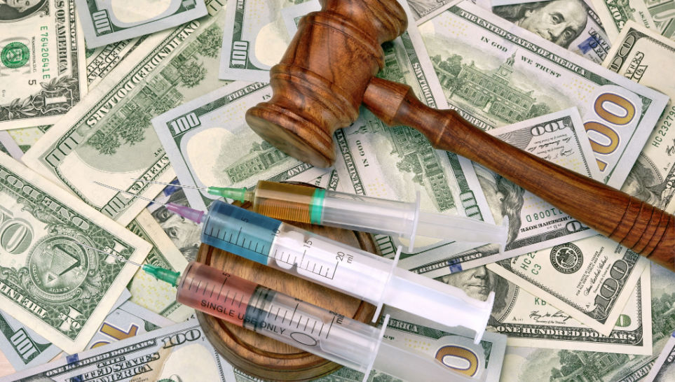 wood gavel and medical syringe on the dollar cash background