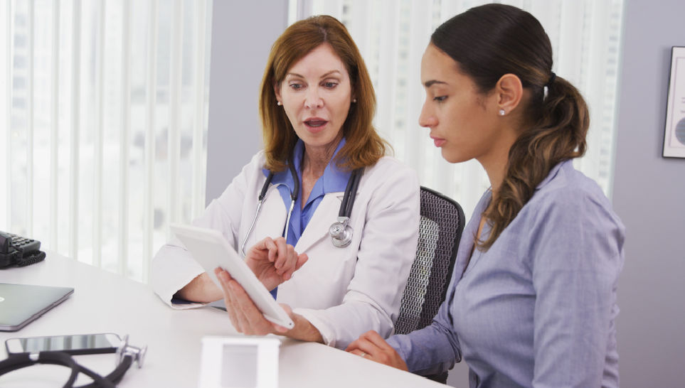 female doctor using tablet explaining the hepatitis b vaccine