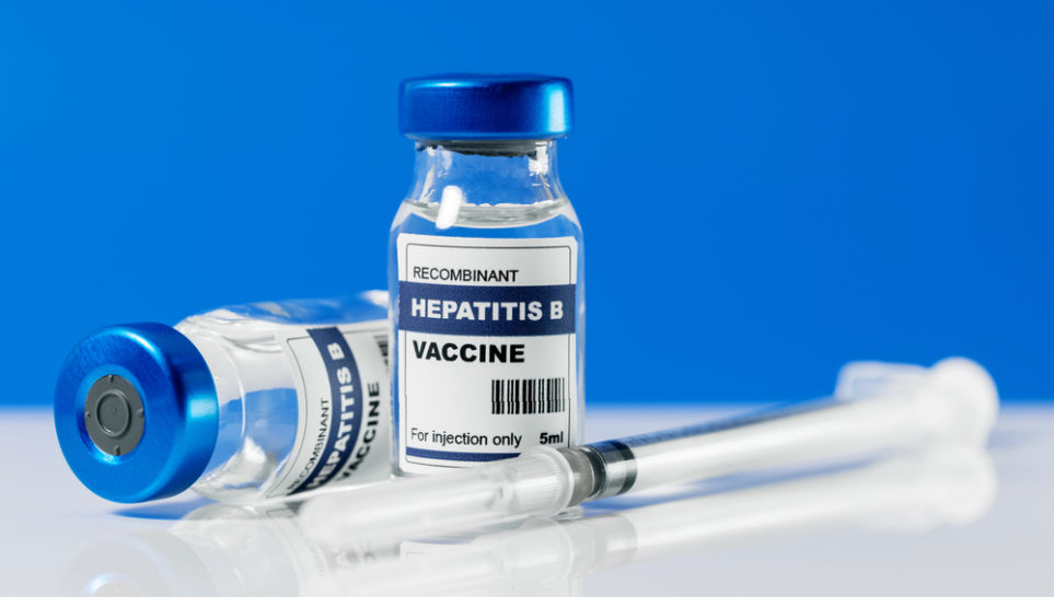 hepatitis b vaccine and syringe on blue background