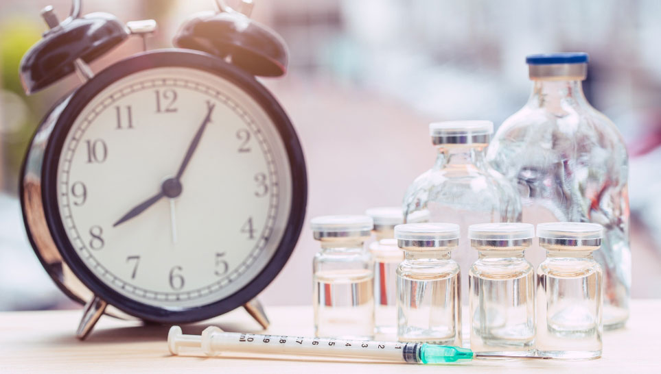 alarm clock with syringe and bottles