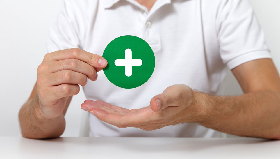 man holding plus sign printed in green circle