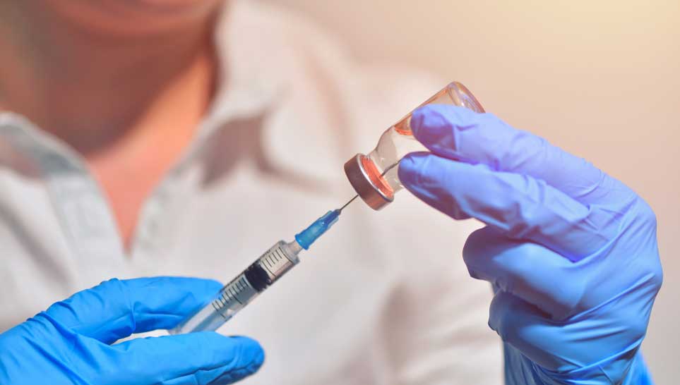 nurse holding vaccine bottle with syringe