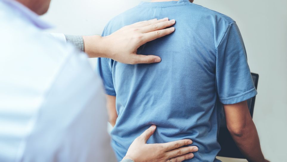 doctor checking patients back pain