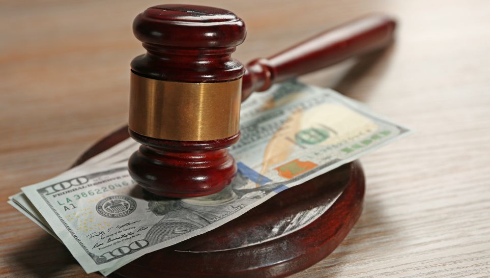 judge gavel and dollar banknotes on table