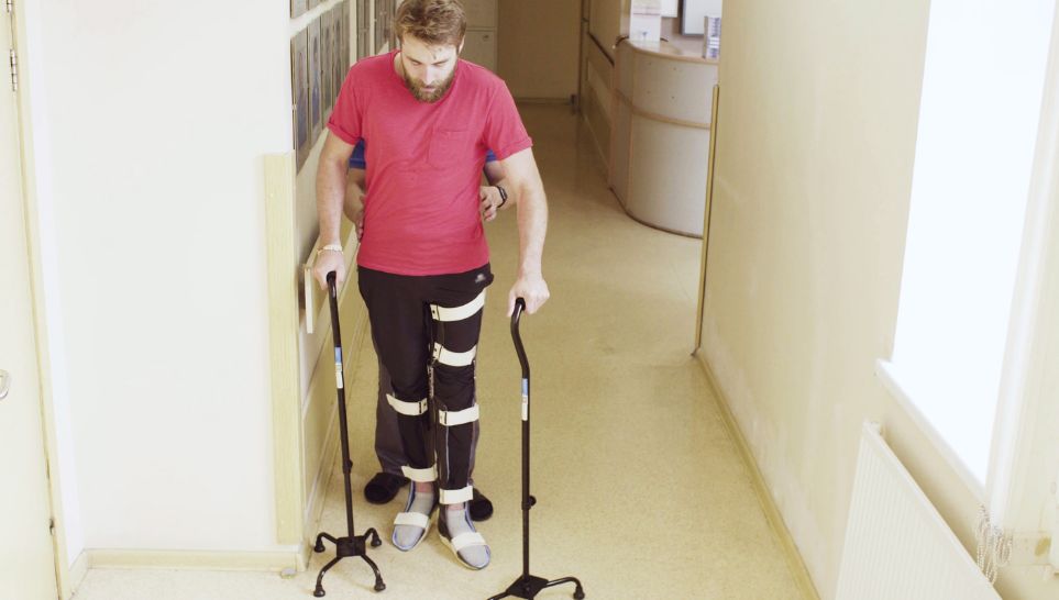 patient waling with support of two walking crane