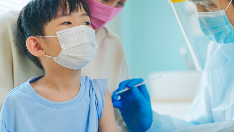 kid receiving pneumonia shot from nurse