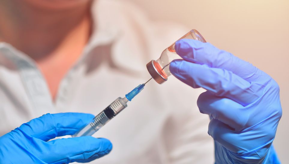 nurse holding vaccine bottle with syringe