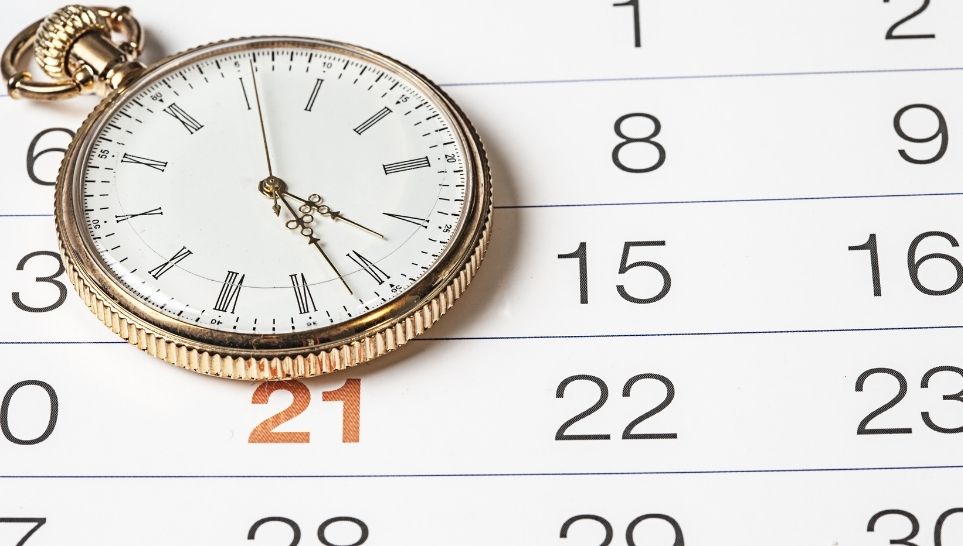 golden clock and calendar with red mark in number twenty one