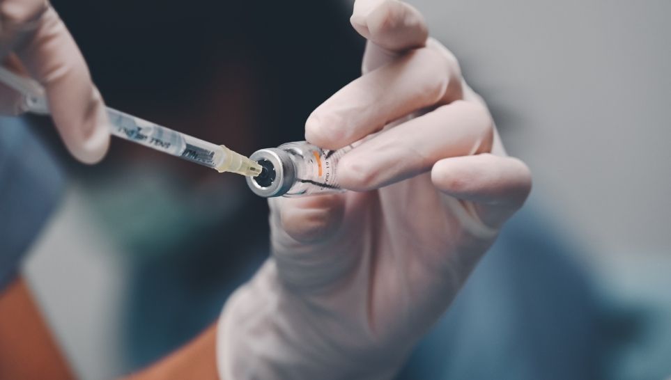 nurse getting vaccine from vial