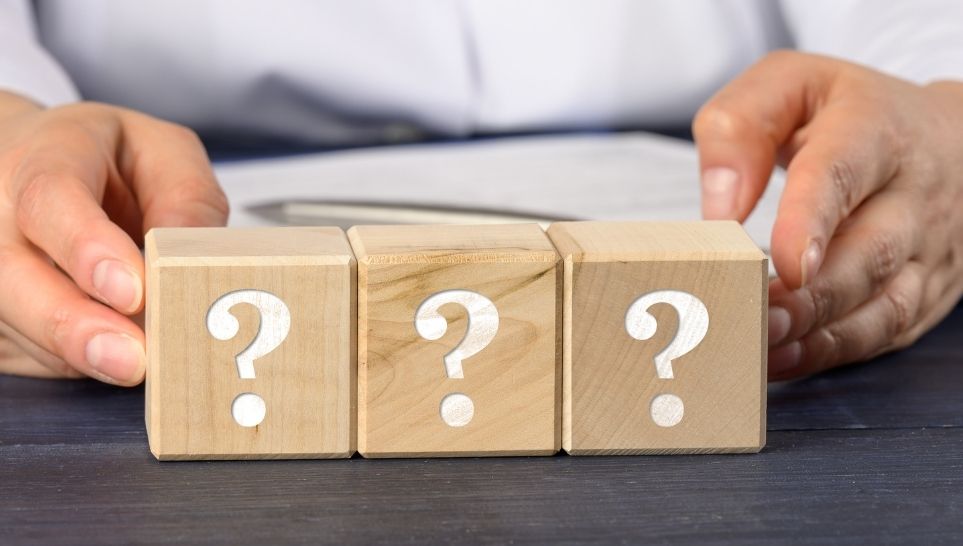 woman holding wooden cubes with question marks